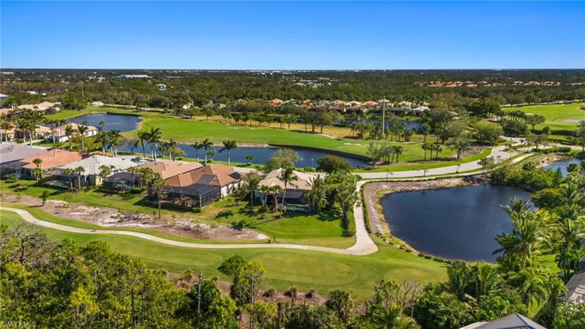 Birds eye view of property featuring golf course view and a water view