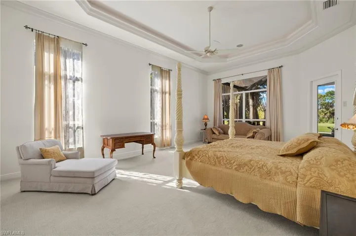 Bedroom with carpet, access to outside, a tray ceiling, and ornamental molding
