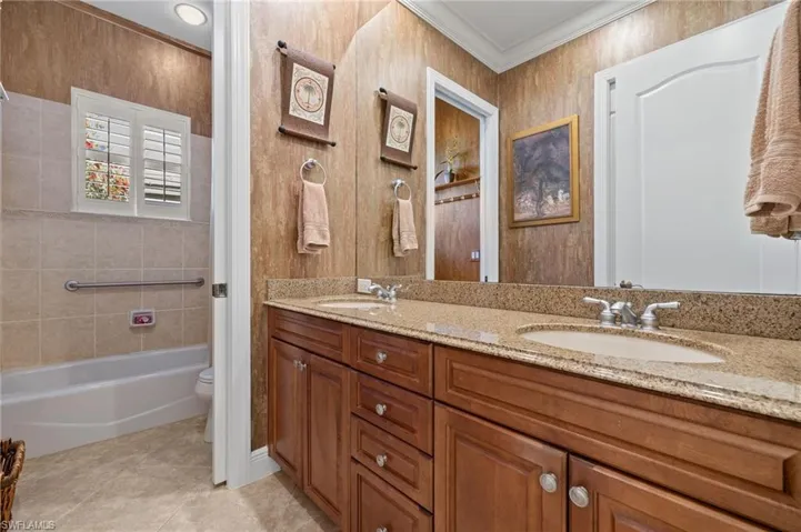 Full bath featuring ornamental molding, a sink, toilet, and tile patterned floors