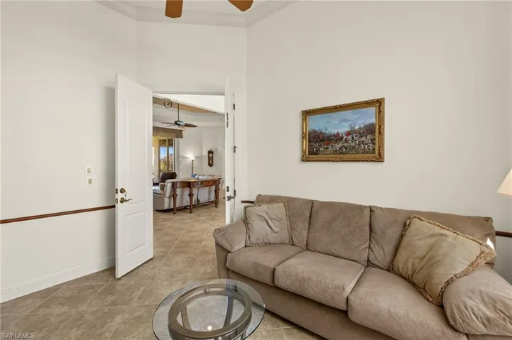 Living room with ceiling fan, baseboards, and crown molding