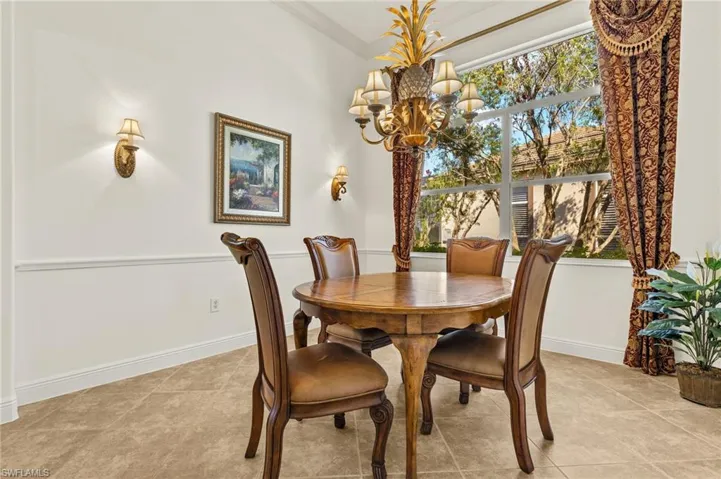 Dining room featuring a chandelier, crown molding, and baseboards