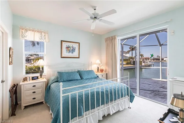Carpeted bedroom featuring ceiling fan and access to exterior