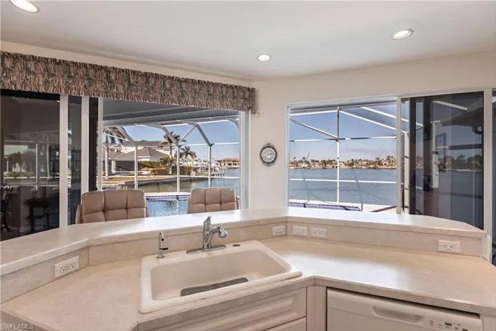 Kitchen featuring a water view, dishwasher, and sink