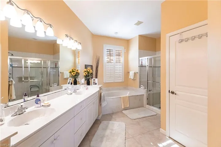 Bathroom featuring vanity, tile patterned flooring, and separate shower and tub