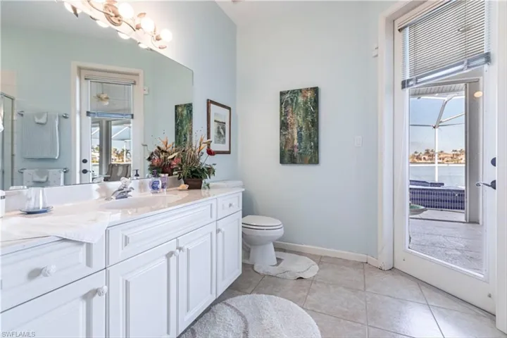 Bathroom with vanity, an enclosed shower, tile patterned flooring, and toilet