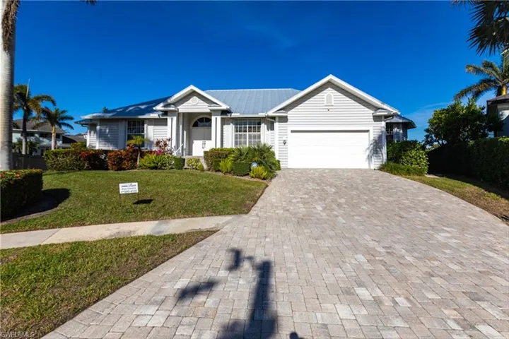 Ranch-style home featuring a garage and a front lawn