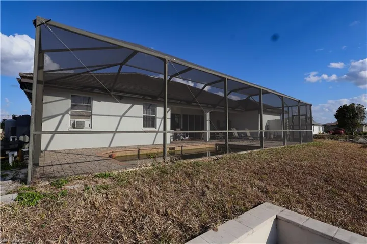 Rear view of house with a sunroom and a lanai