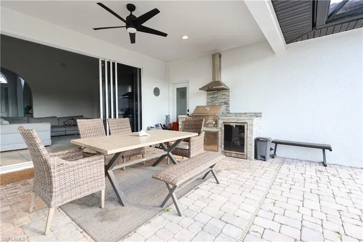 View of patio featuring a ceiling fan, an outdoor kitchen / dining area, and a fireplace