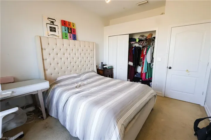 Carpeted bedroom with a closet