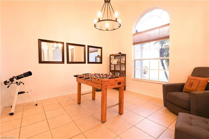 Game room with light tile patterned floors and hanging lights