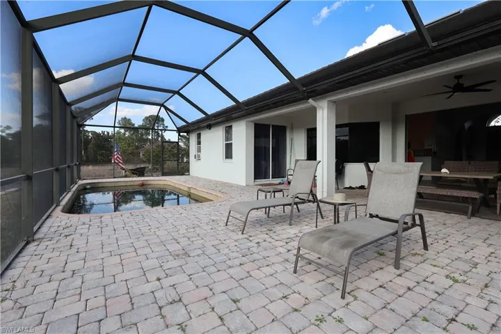 View of patio featuring a sunroom, a lanai, ceiling fan, and an outdoor pool