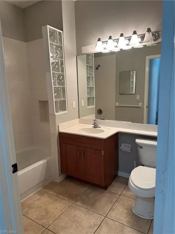 Full bathroom with vanity, light tile patterned flooring, and shower / bathtub combination