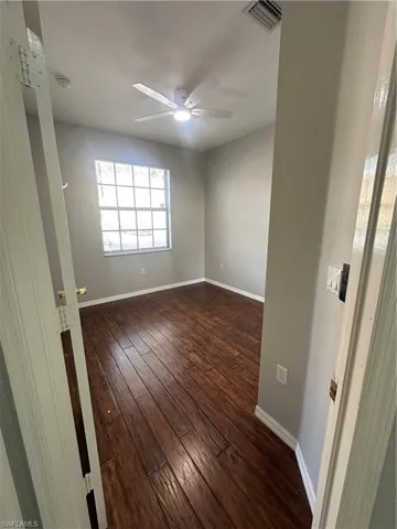 Spare room featuring dark wood-style floors and a ceiling fan