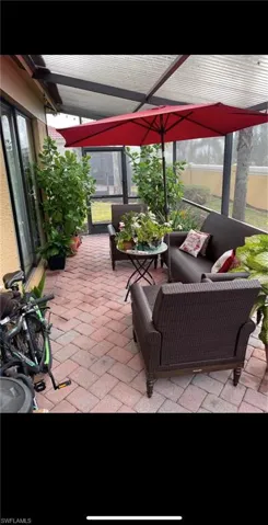 View of patio with glass enclosure and a sunroom