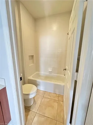 Bathroom with light tile patterned floors, vanity, and bathing tub / shower combination