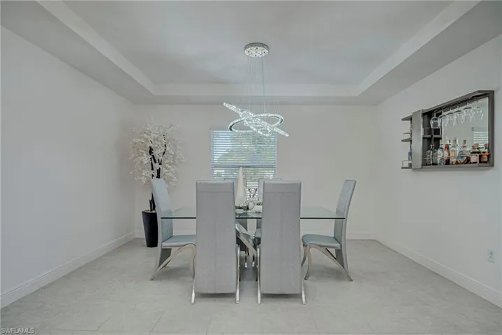 Dining room with a raised ceiling and a chandelier