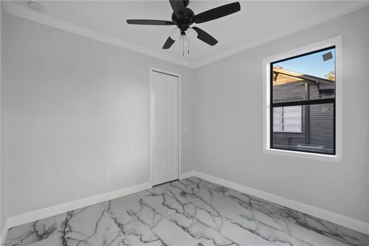 Unfurnished room with crown molding and ceiling fan