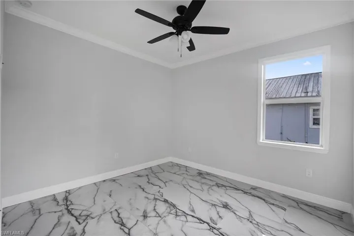Unfurnished room with ceiling fan and crown molding