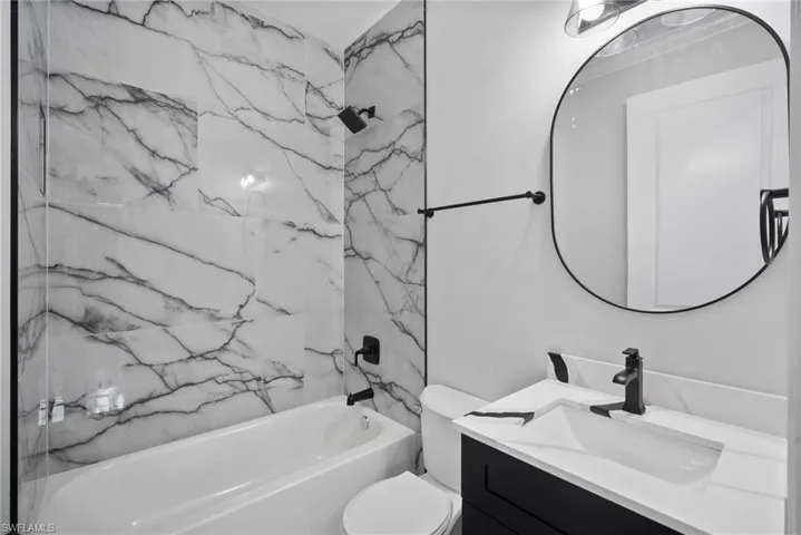 Full bathroom featuring vanity, toilet, and tiled shower / bath