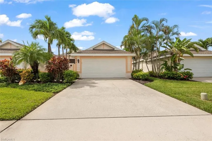 Ranch-style home featuring a front yard, concrete driveway, and stucco siding
