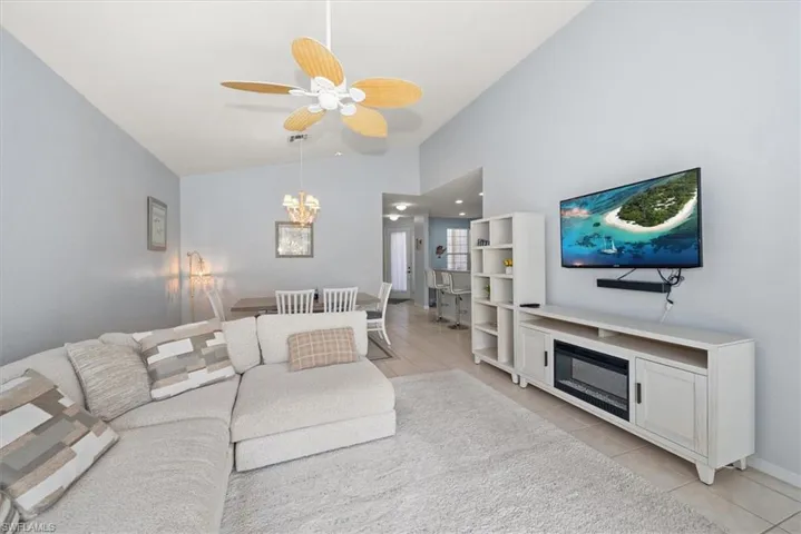 Living area featuring light tile patterned floors, a ceiling fan, a fireplace