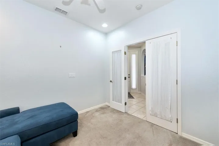 Living area featuring light carpet and ceiling fan