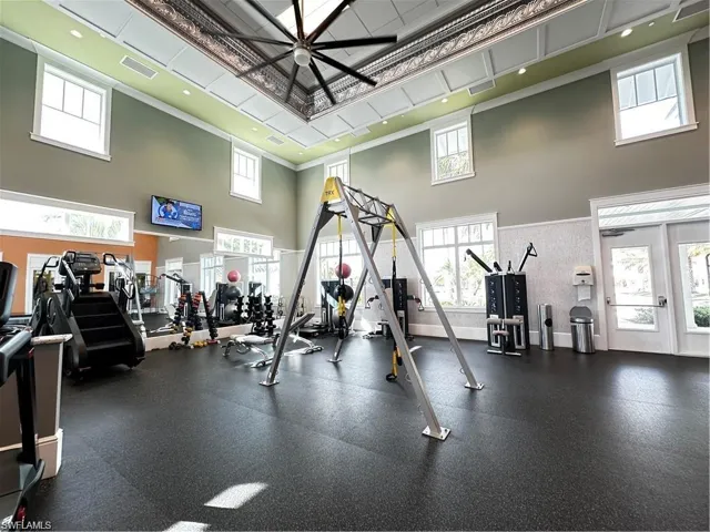 Workout area with a high ceiling and a ceiling fan