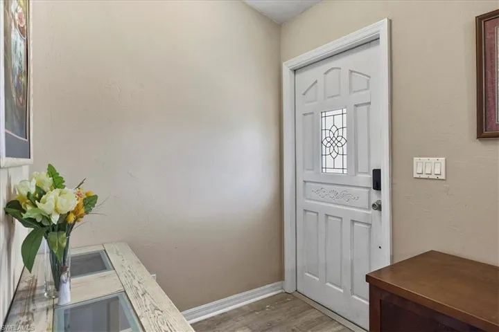 Entryway featuring baseboards and wood look finished floors