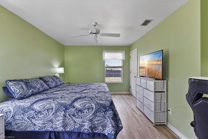 Master bedroom featuring baseboards, ceiling fan and wood look finished floors