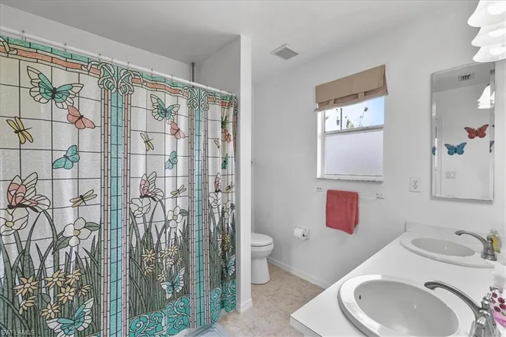 Full bathroom featuring visible vents, a sink, toilet, and double vanity