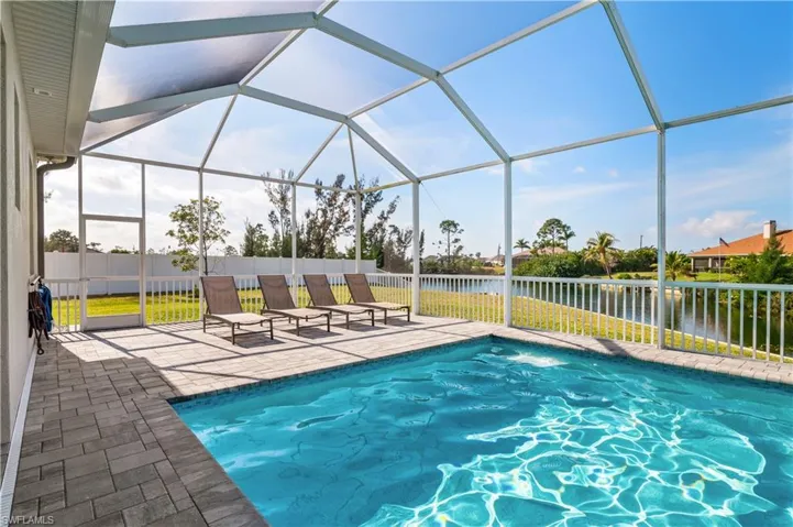 View of pool with a fenced in pool, a patio, a water view, fence, and a lanai