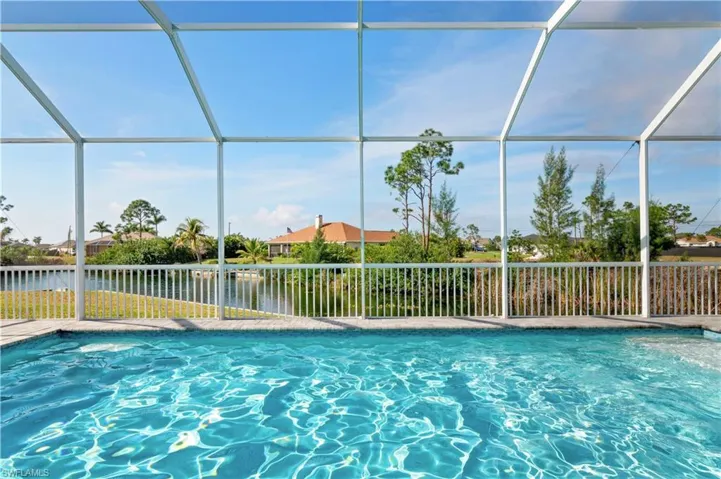 View of pool featuring a water view, a lanai, and a fenced in pool