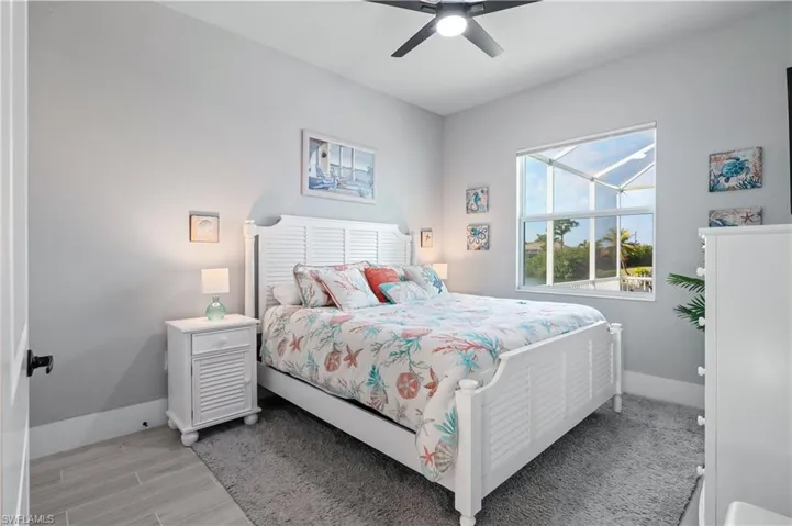 Bedroom with light wood-style floors, baseboards, and a ceiling fan