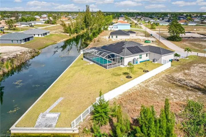 Birds eye view of property featuring a water view and a residential view
