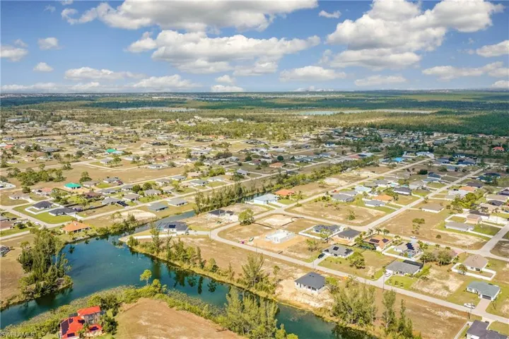 Birds eye view of property with a water view and a residential view