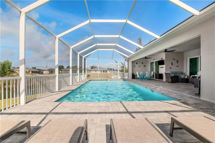 View of pool with a patio area, a lanai, a ceiling fan, and a fenced in pool