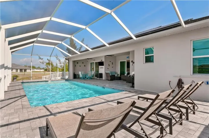 View of pool featuring a ceiling fan, a fenced in pool, a lanai, fence, and a patio area