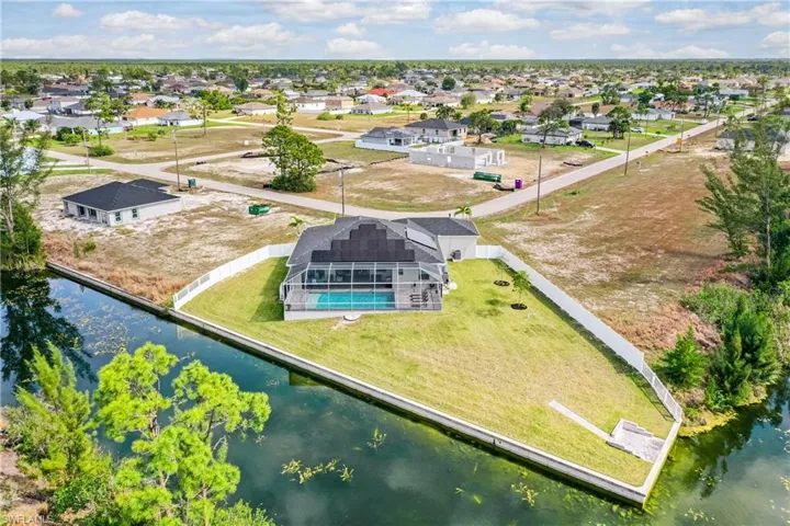 Birds eye view of property with a water view and a residential view