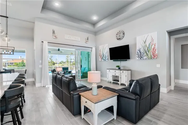 Living room featuring light wood finished floors, baseboards, and a chandelier