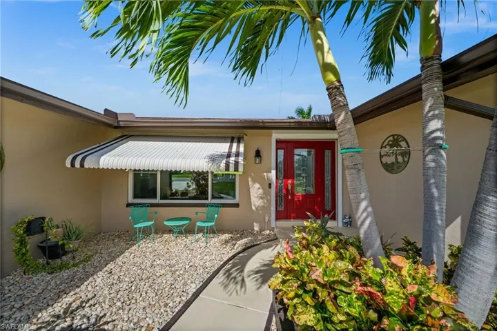 Welcoming front entry with tropical landscaping.