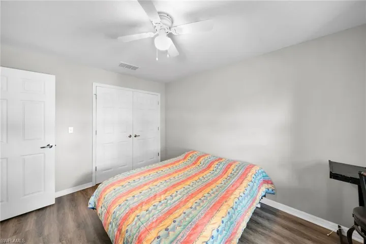 Bedroom featuring dark hardwood / wood-style flooring, a closet, and ceiling fan