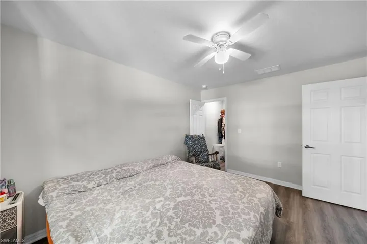 Bedroom with ceiling fan, hardwood / wood-style floors, and a walk in closet