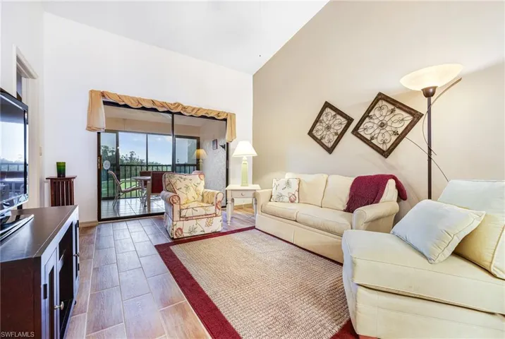 Living room with hardwood / wood-style floors and high vaulted ceiling