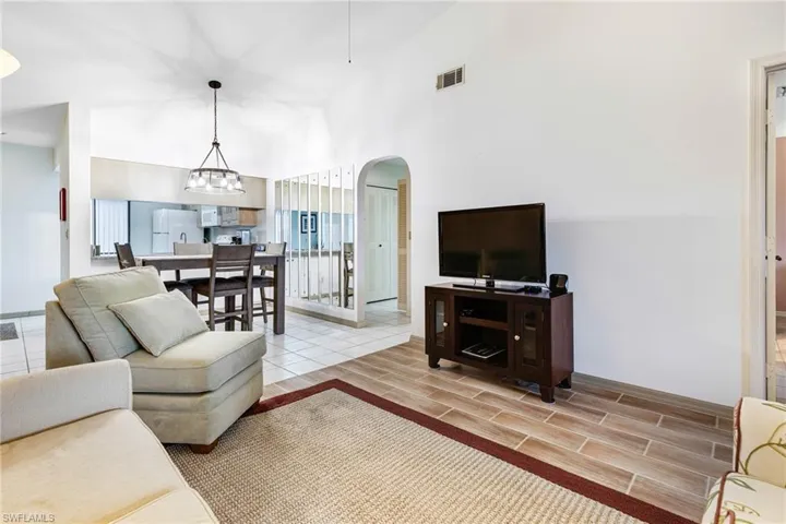 Living room featuring vaulted ceiling and an inviting chandelier