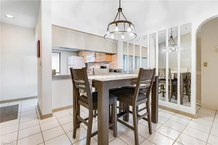 Dining space with light tile patterned floors and an inviting chandelier