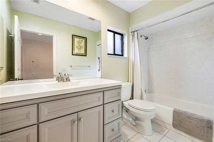 Full bathroom featuring tile patterned floors, vanity, toilet, and shower / bath combination with curtain