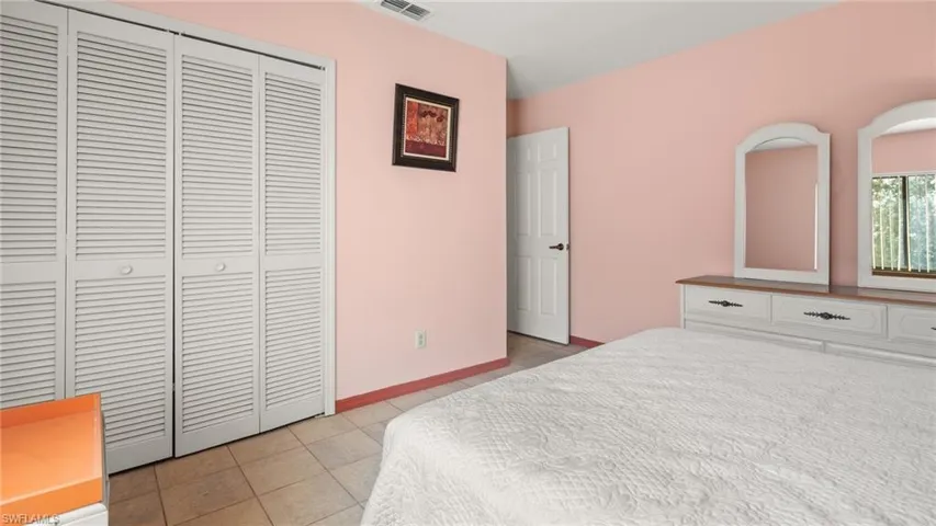 Bedroom with light tile patterned floors and a closet