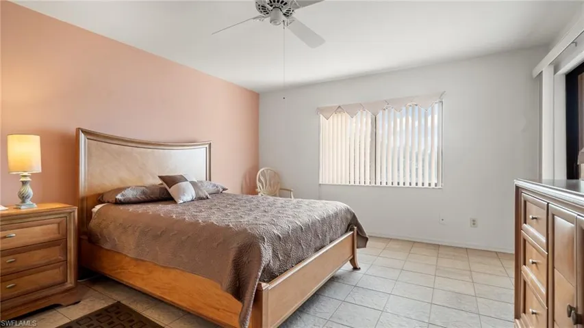 Tiled bedroom featuring ceiling fan