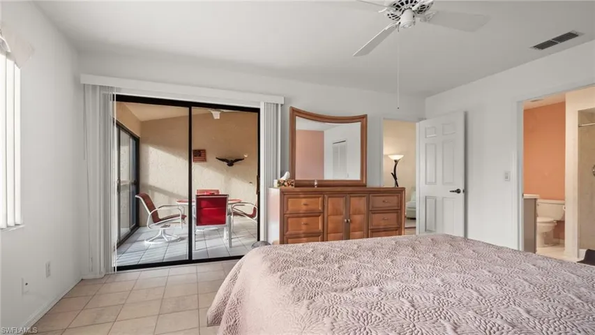 Tiled bedroom with ceiling fan, connected bathroom, and a closet