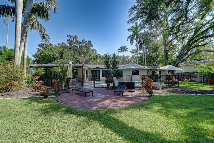 Back of property featuring a patio area and a lawn